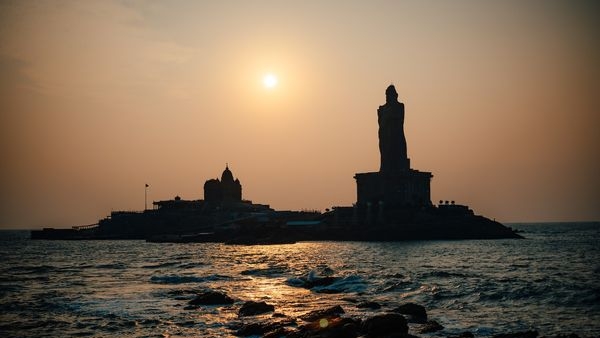 An iconic view of Kanyakumari with the Vivekananda Rock Memorial and Thiruvalluvar Statue outlined against the spectacular winter sunset