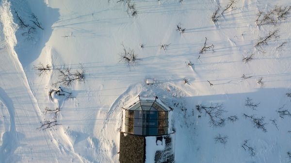 A glass igloo in Finland under the starlit winter sky