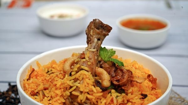 A plate of aromatic Lucknowi biryani served alongside succulent kebabs