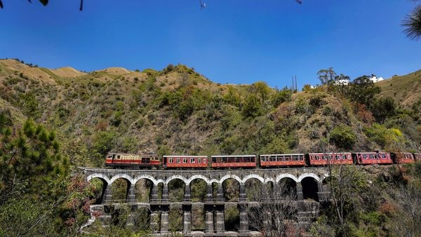 Image alt text: A picturesque view of the Kalka-Shimla Toy Train journey through the majestic Shimla Hills. Image alt text: A picturesque view of the Kalka-Shimla Toy Train journey through the majestic Shimla Hills.