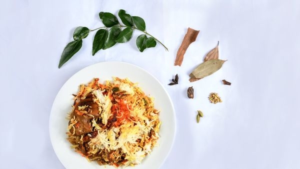 Image of a pot filled with aromatic Lucknow Biryani garnished with fresh coriander Image of a pot filled with aromatic Lucknow Biryani garnished with fresh coriander