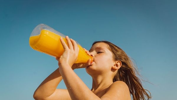 Mother applying sunscreen on child at beach